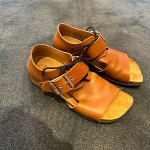 John Fluevog PEACEMAKER
RIGOBERTA
LACE-UP BUCKLE SANDALS